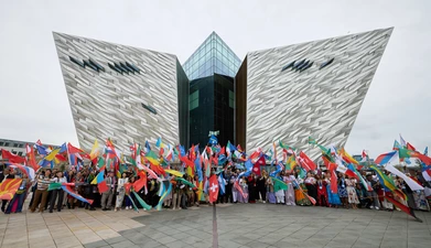 Flag beareres in front of the Titanic building in Belfast