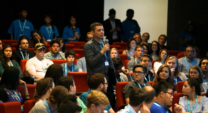 Young person asking a question in a university